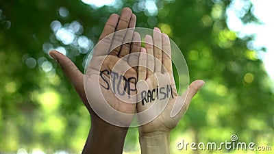 Interracial people hands with stop racism phrase, fight against discrimination Stock Photo
