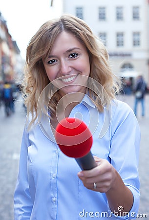 Interview of a young woman with blond hair in the city Stock Photo