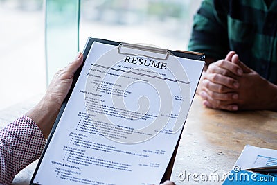 Interviewer reading a resume, Person submits job application, Person describe yourself to interviewer, Close up view of job Stock Photo