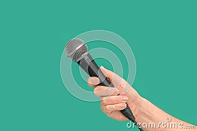 Interviewer or reporter with microphone in hand on green background Stock Photo