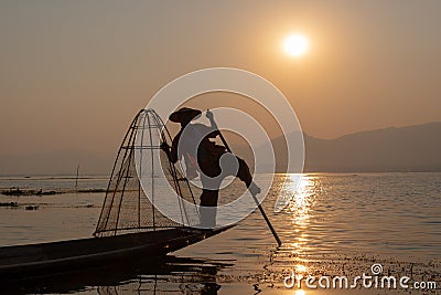 Intha traditional leg rowing fisherman on Inle lake at sunset, Burma, Myanmar Stock Photo