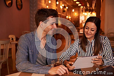 Intimately smiling millenial couple in restaurant Stock Photo