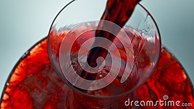 Intoxicant red beverage filling decanter slow motion. Wine forms waves glassware Stock Photo