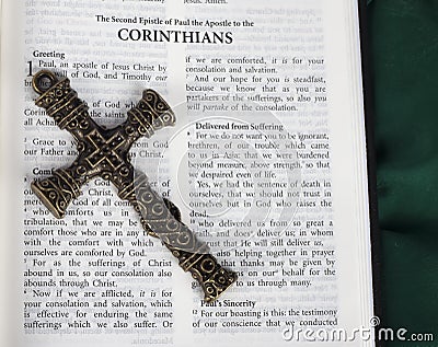 Intricate antique cross with Corinthians verse in Holy Bible Stock Photo