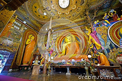 Intricate artwork & iconic large seated Buddha image in `earth touching` pose, interior Gangaramaya Temple, Colombo, Sri Lanka Editorial Stock Photo