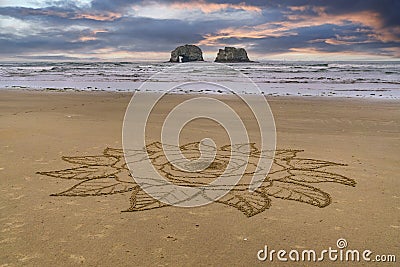 Intricate flower sand art on a beach. Stock Photo