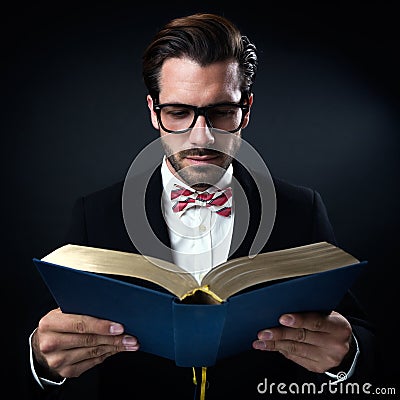 Intrigued businessman with glasses reading a book. Isolated on b Stock Photo