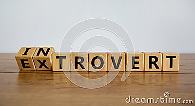 Introvert or extrovert symbol. Fliped cubes and changed the word `introvert` to `extrovert`. Beautiful wooden table, white Stock Photo
