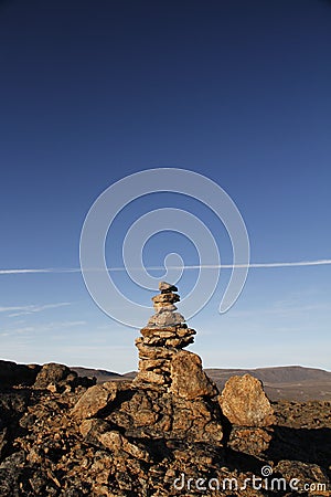 Inukshuk or Inuksuk at the top of the mountain along a hiking trail near the community of Qikiqtarjuaq Stock Photo