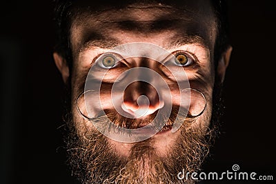 Inventor Hipster with Beard and Mustages in the Dark Room. Smiling Trickster. Stock Photo