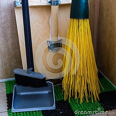 Inventory for cleaning the territory: a shovel, a broom and a scoop are in the corner Stock Photo