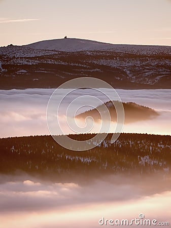 Inverse weather in mountains, shinning fog. Misty valley in winter Stock Photo