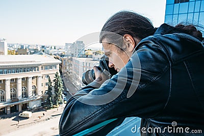 Investigator or private detective or reporter or paparazzi taking photo from balcony of building with professional camera Stock Photo