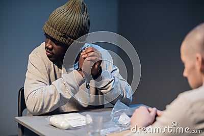 The investigator submits the evidence of guilt of a black drug dealer Stock Photo