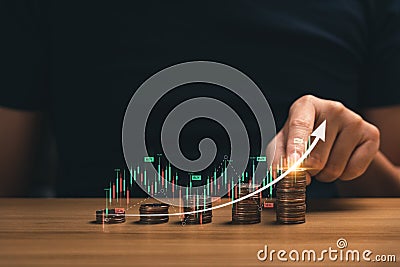 investment concept in financial business. Businessman`s hands with stacks of coins showing father graph chart with arrows Stock Photo