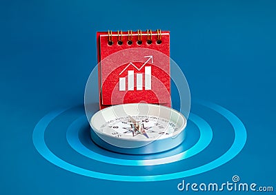 usiness growth graph icon on red desk calendar cover standing near compass on blue background with target dart symbol. Stock Photo