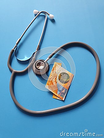 investment in health care, Swiss money and stethoscope for medical check Stock Photo