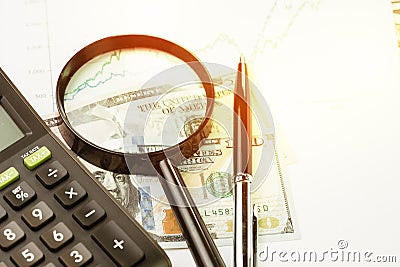 Investment, stock or equity, search for yield concept, magnifying glass, pen and calculator on performance, market price numbers Stock Photo