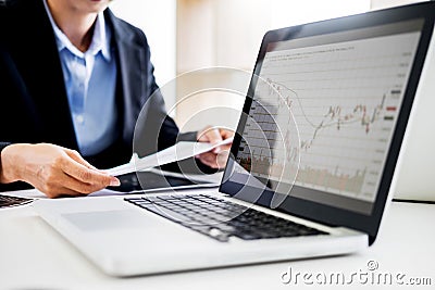 Investor analyzing financial reports of stock trading Market Graph investment charts on computer monitor screen in the office Stock Photo