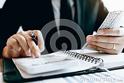 Investors are calculating on calculator investment costs and holding cash notes in hand Stock Photo