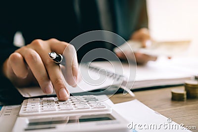 Investors are calculating on calculator investment costs and holding cash notes in hand Stock Photo