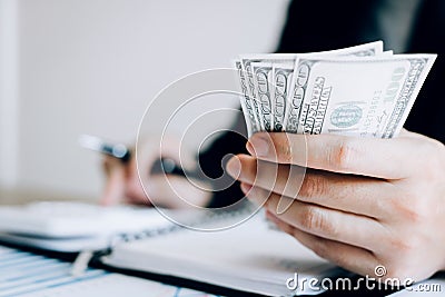 Investors are calculating on calculator investment costs and holding cash notes in hand Stock Photo