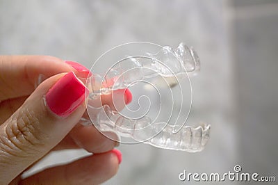 Invisible dental retainer held by womans hand Stock Photo