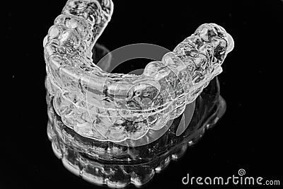 Invisible transparent dental removable braces on the black background. Orthodontic appliance for dental correction Stock Photo