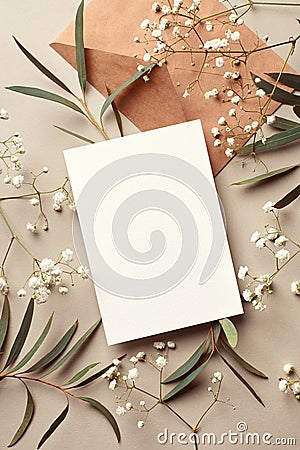 Invitation or greeting card mockup with envelope, eucalyptus and gypsophila twigs. Card mockup with copy space. Stock Photo