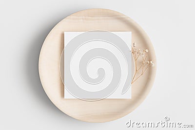 Invitation square card mockup on a wooden plate with a gypsophila Stock Photo