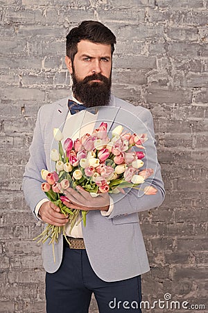 Invite her dating. Romantic man with flowers. Romantic gift. Macho getting ready romantic date. Waiting for darling Stock Photo