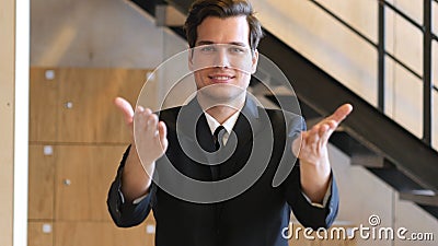 Inviting Gesture by Young Man in Suit Stock Photo