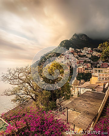 Inviting pathway lined with bright pink flowers against an urban backdrop in Positano Italy Editorial Stock Photo