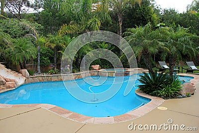 Inviting scene of backyard oasis with pool, chairs and beautiful landscape Stock Photo