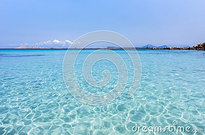 Inviting turquoise mediterranean sea with reflections - mountain range and rocks in the background, Capriccioli beach, Sardinia, I Stock Photo