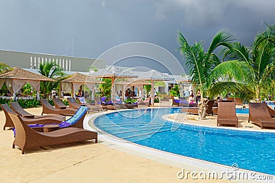 Inviting view of a curved wide open comfortable swimming pool with people relaxing and enjoying their time Stock Photo