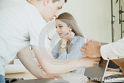 Involvement in the workflow. A young female employee is busy with work and is not distracted by the noise and work of other Stock Photo