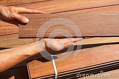 Ipe deck installation carpenter hands holding wood Stock Photo