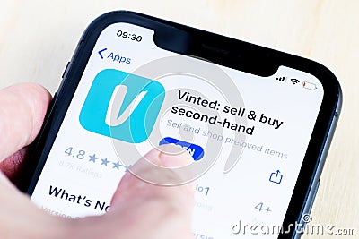 Iphone screen with vinted logo displayed with hand. Editorial Stock Photo