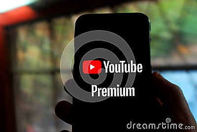 Iphone with the YOUTUBE PREMIUM logo. YouTube Premium is a paid streaming subscription service for YouTube Editorial Stock Photo