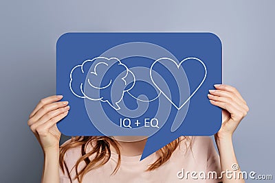 iq eq concept. girl holding poster with hand drawing a brain and heart Stock Photo