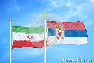 Iran and Serbia two flags on flagpoles and blue cloudy sky Stock Photo