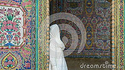 Woman leaning to a door with colored tiles Nasir al-Mulk Mosque, Shiraz, Iran Editorial Stock Photo