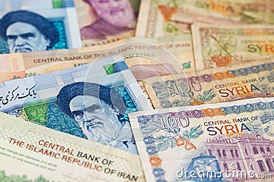 Iranian Rial and Syrian Pounds currency banknotes close up image. Stock Photo