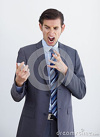 Irate. A furious businessman looking at a text message on his smartphone. Stock Photo