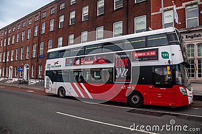 Ireland. Cork. An urban bus runs along the north bank of the River Lee, in front of the CEC, Cork English College Editorial Stock Photo