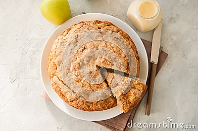 Irish apple pie on a white plate with vanilla custard sauce. Festive dessert for St.Patricks Day. Stock Photo