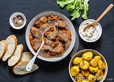 Irish beef stew and turmeric potatoes - delicious seasonal lunch on a dark background, top view. Flat lay. Stock Photo