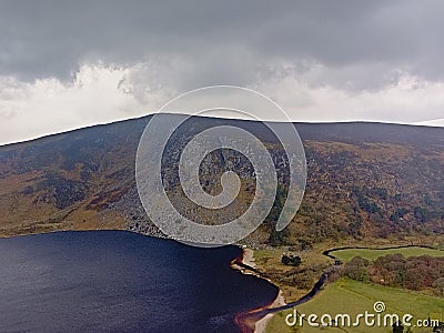 Dark clouds over Guiness lake in wicklow mountains Stock Photo