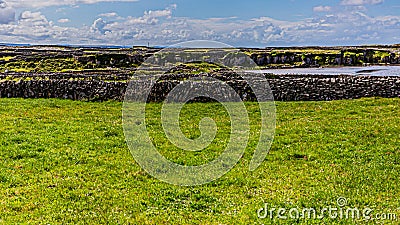 Irish landscape with limestone fences on the island of Inis Oirr with a small beach in the background Stock Photo